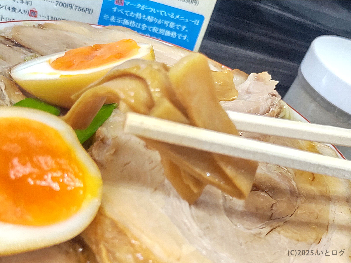 みずさわ屋の中華そばを箸で持ち上げたメンマと味玉。しっとりしたチャーシューの上に黄金色の半熟卵が映える。仙台の人気ラーメン店らしい丁寧な一杯。