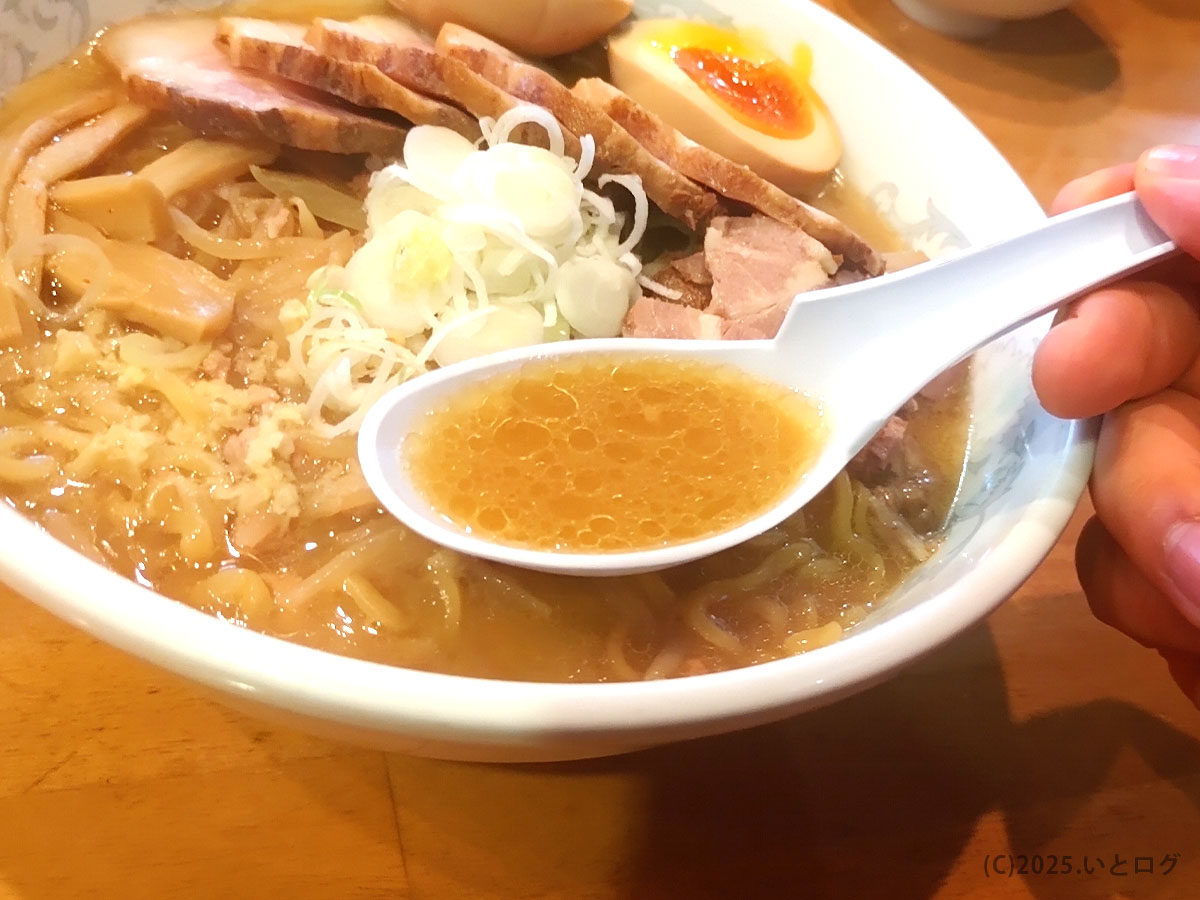純連 仙台の味噌ラーメンのスープをレンゲですくった様子。熱々で濃厚な味わいが特徴のみそスープが際立っている。