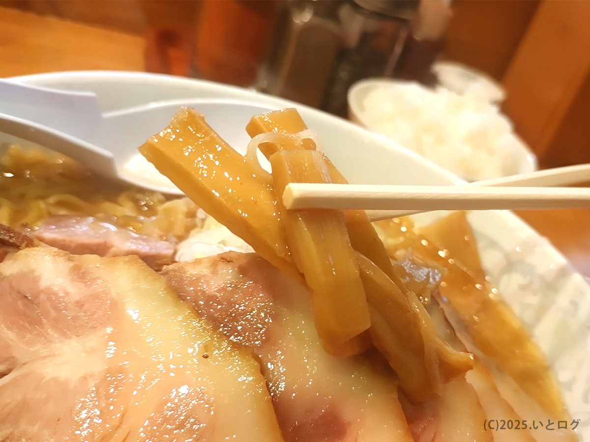 純連 仙台の味噌ラーメンのメンマを箸で持ち上げたカット。みそスープがしっかり染みた風味豊かなメンマが特徴。