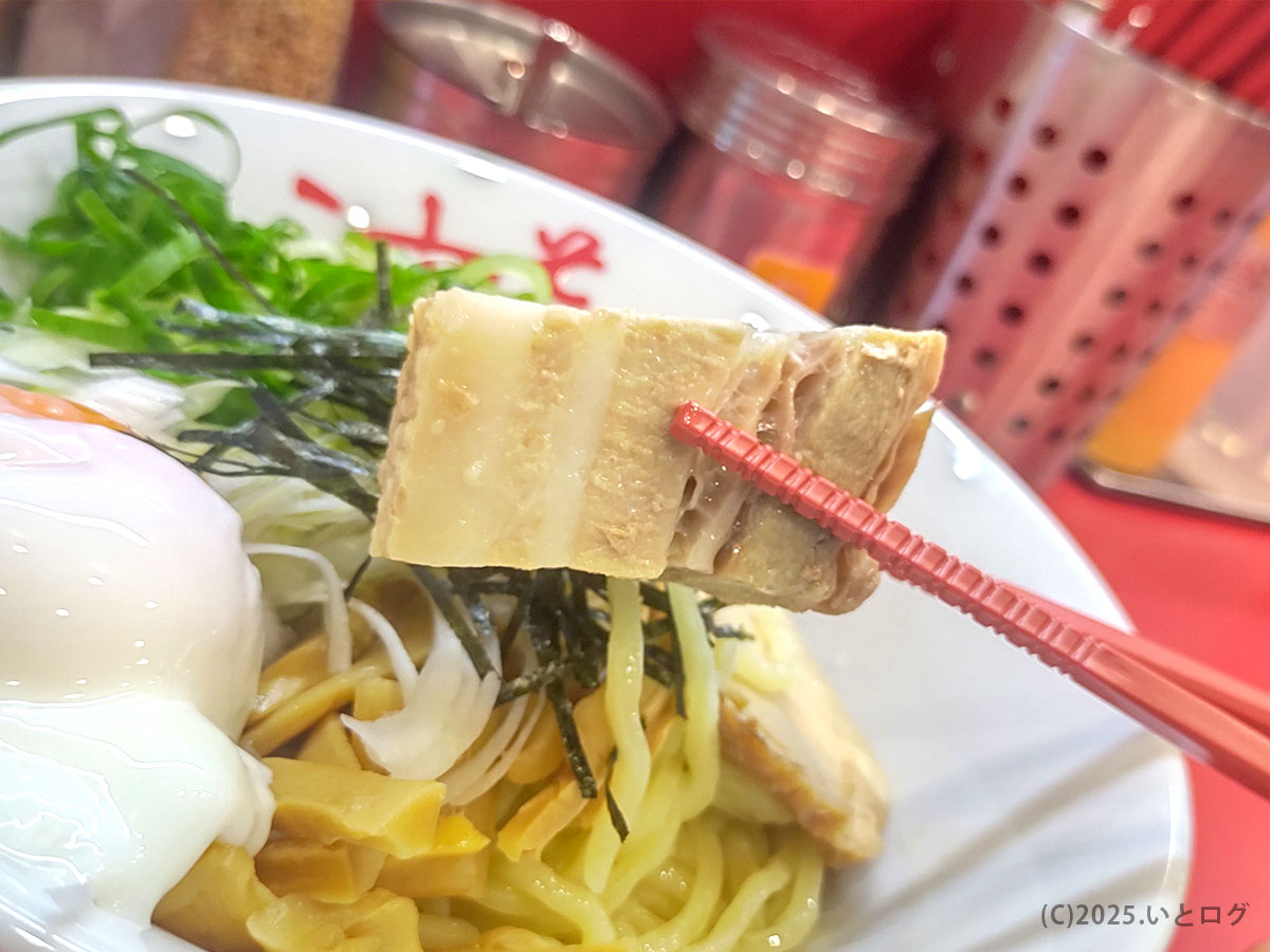厚さ2㎝ほどの豚バラチャーシューを赤箸でリフト。カロリー度外視でとろける脂がタレと絡む、満足感抜群の具材。