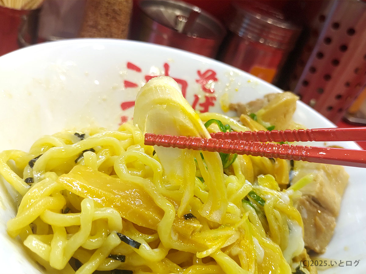よく混ぜた縮れ麺にタレと香味油が艶やかに絡む。油そば 甲府屈指の旨さを赤箸で持ち上げる瞬間。