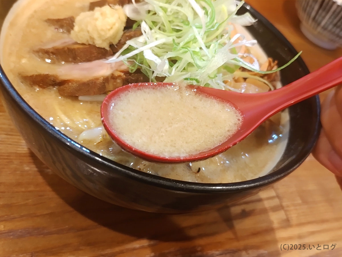 濃厚味噌スープを赤レンゲですくい上げる瞬間──店名“初志貫徹”の意味を体感するクリーミーな一口。