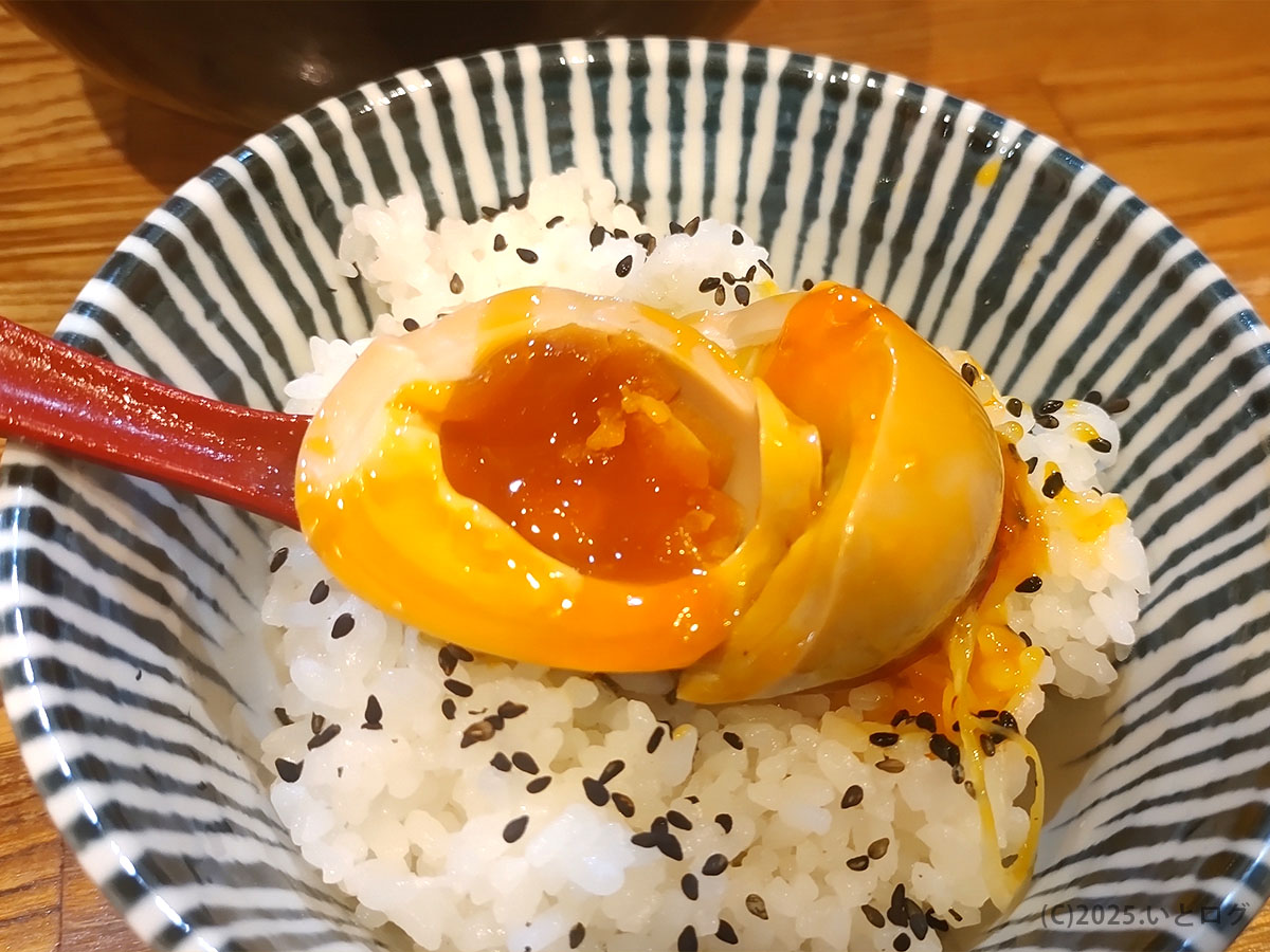 とろける味玉をご飯にのせた“追い飯”スタイル。黄身がごはんに絡む贅沢な仕上げ。