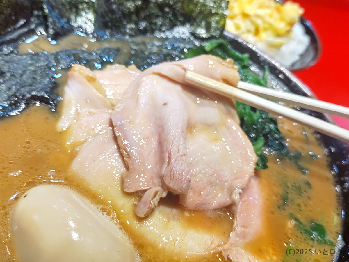 カズ家 大森店のチャーシューを箸で持ち上げたカット。厚みがありつつ柔らかい仕上がりで、品川区の家系ラーメンの中でも人気の要素になっている。