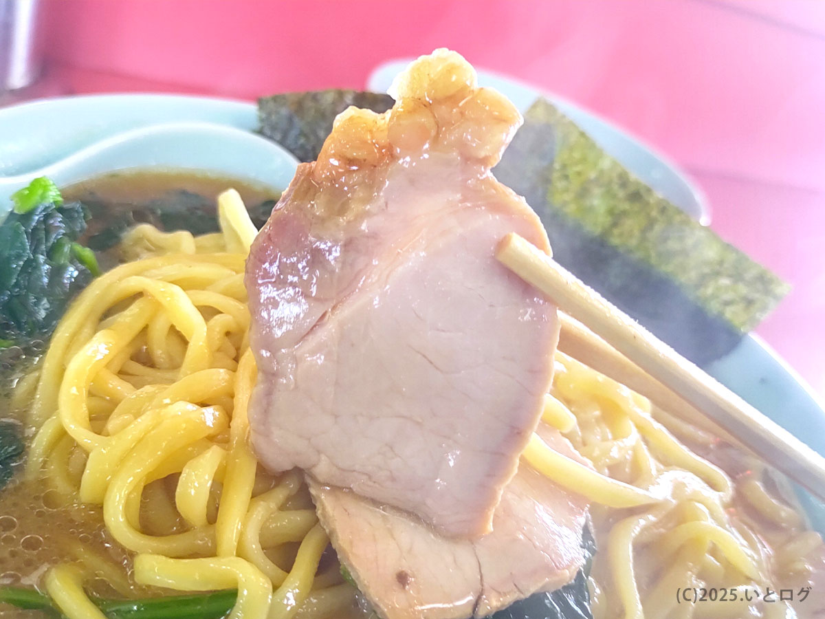 沼津家 ラーメンの厚切りチャーシューを持ち上げた様子。肉感しっかりの家系チャーシューで、沼津家 肉まみれ系トッピングにも関連。吉村家直系とは異なる味わいの比較レビューにも使われる。