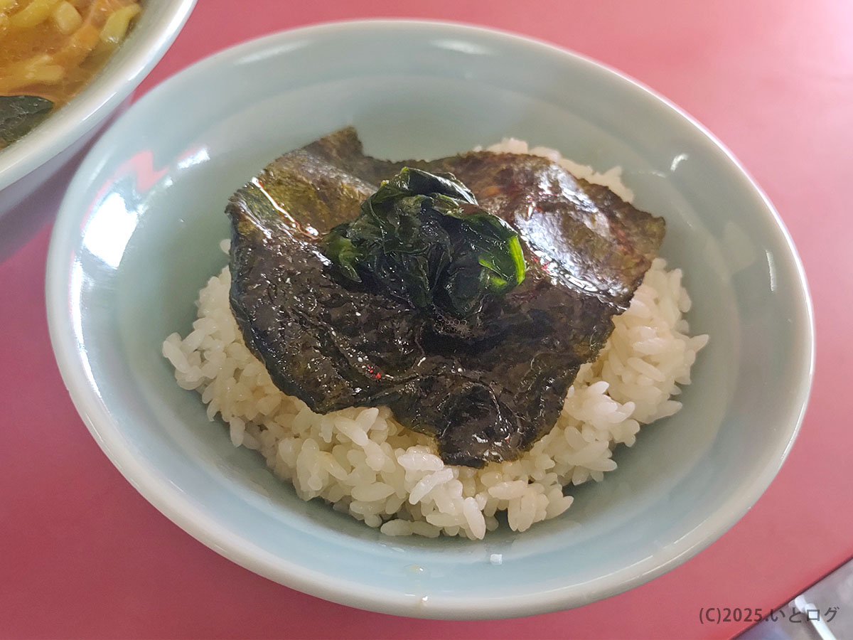 家系ラーメン 沼津家の席で、海苔とほうれん草をのせたライス。卓上スープをかければ沼津家系らしい味変ができ、黒塩ラーメンやチャーシューまぶしご飯と並ぶ人気メニューの食べ方例。
