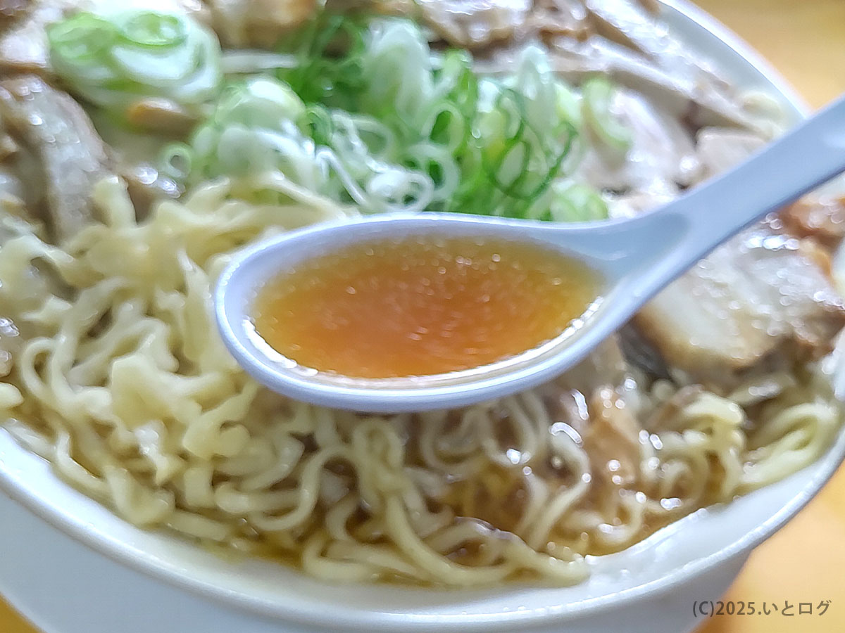 富山県上市町の中華そば あざみ 大岩本店で味わえる醤油スープをレンゲですくった様子。平打ち麺とチャーシューの旨みが溶け込んだ富山ラーメンらしい優しい味わいが伝わる。