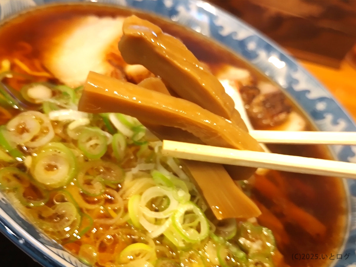大石家 塩尻店のメンマを箸で持ち上げたアップ写真。やわらかく味しみの良いメンマが、大石家ラーメンの素朴な中華そばに良く合う。