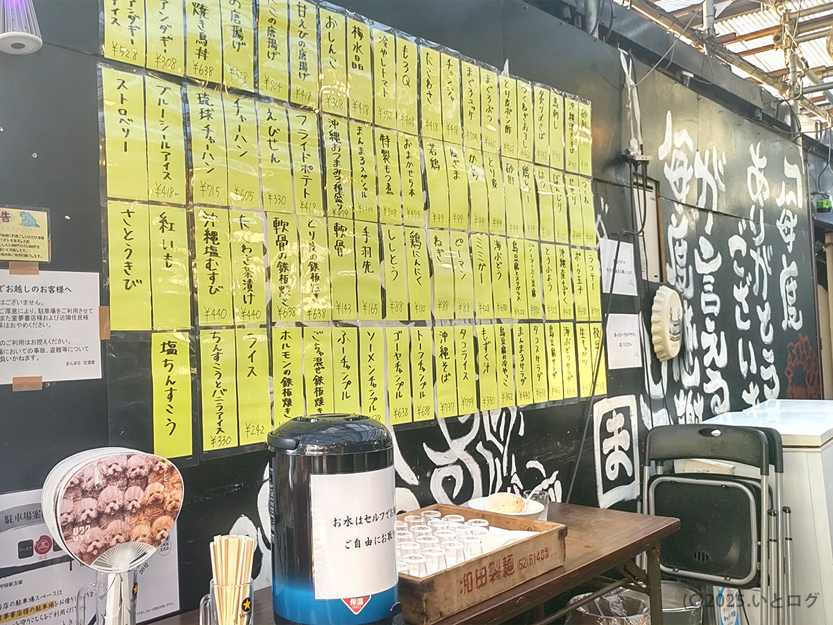 黒壁にずらり貼られた黄色いメニュー札とセルフ給水コーナー。屋台らぁ麺 とき々の活気ある昭和レトロ空間。