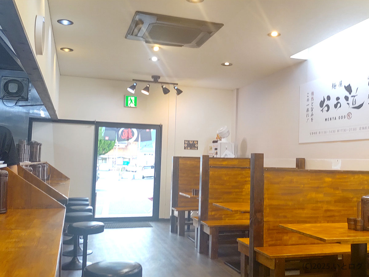 木目カウンターとボックス席が並ぶ明るい店内、奥には麺屋 おう道のロゴ看板と非常口サイン