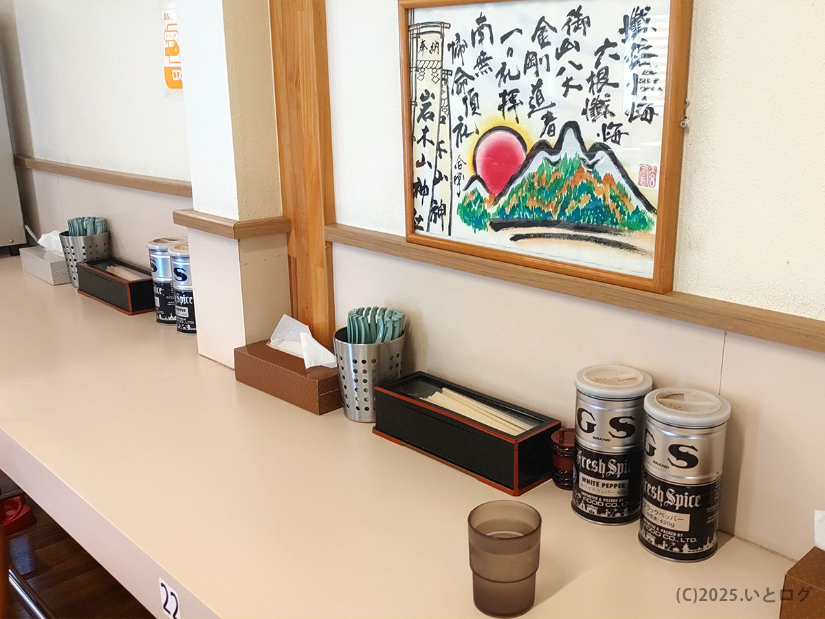 たかはし中華そばのカウンター席と卓上調味料。シンプルな構成でラーメンと向き合える空間。