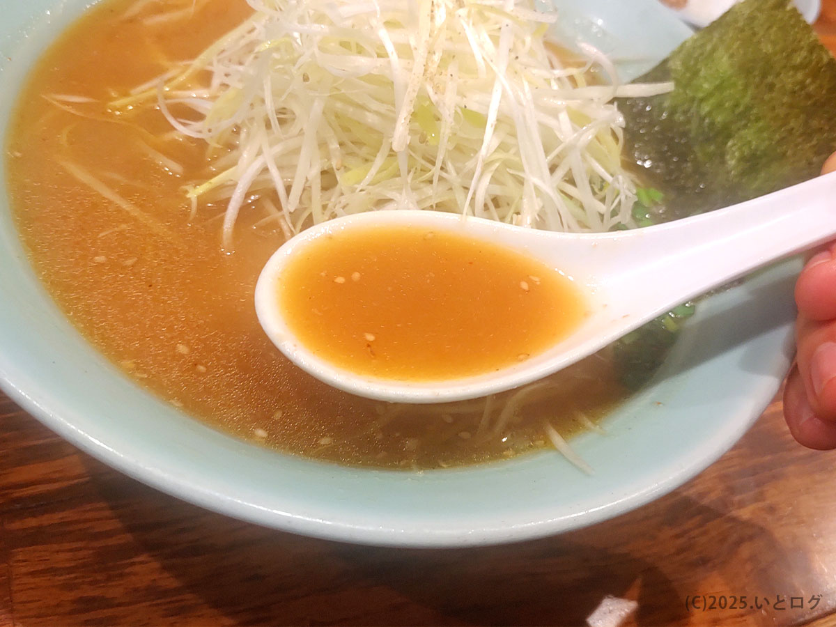 らーめん錦 秋田・大館本店のスープをレンゲですくった一枚。コクがありながらも飲みやすい味わいが特徴