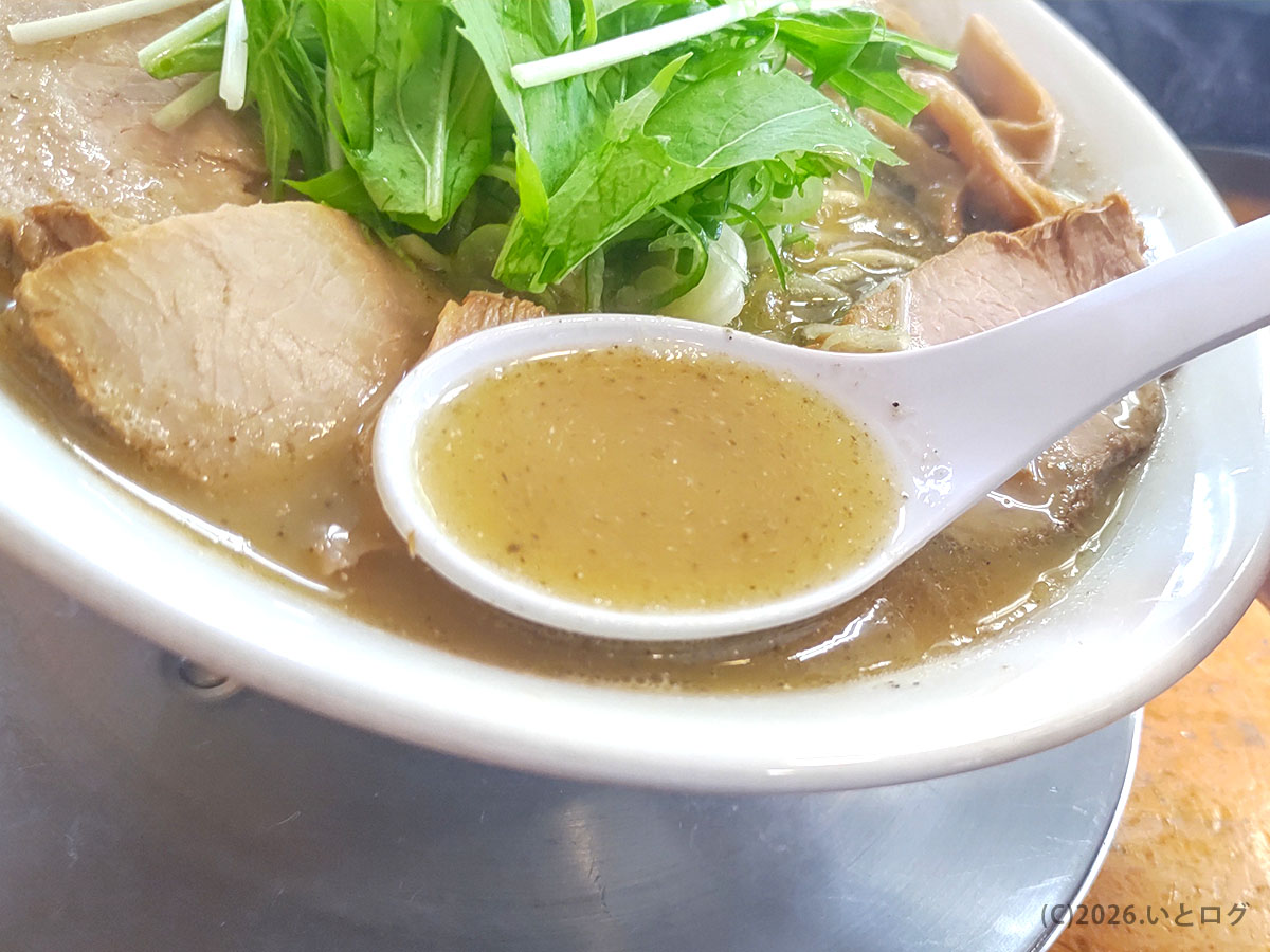 松韻のラーメンスープをすくったレンゲ。秋田の醤油ラーメン名店らしい澄んだ味わい