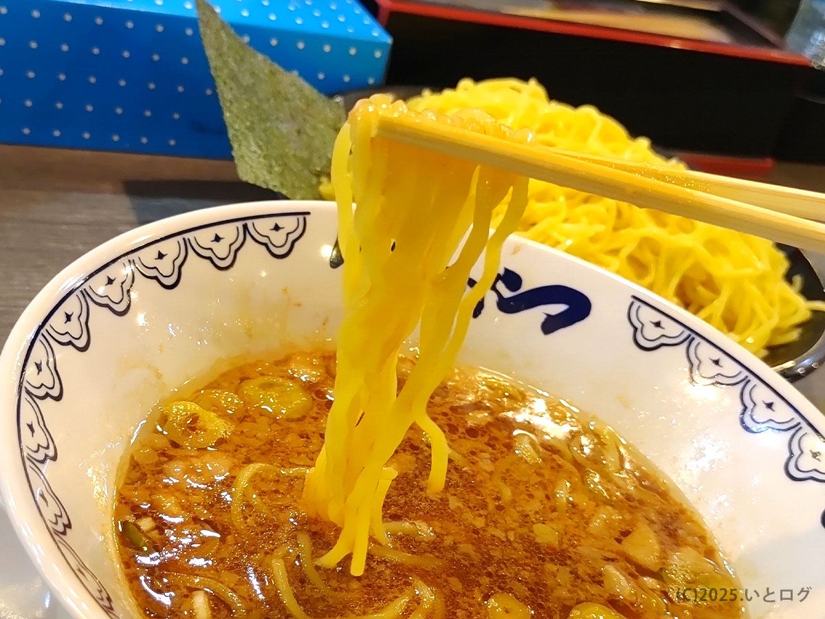 池袋ばんかららーめん 竜王バイパス店のつけ麺を麺リフト。黄色い麺が濃厚なつけ汁に絡み、食欲をそそる光景。山梨で味わえる力強いばんからスタイル。