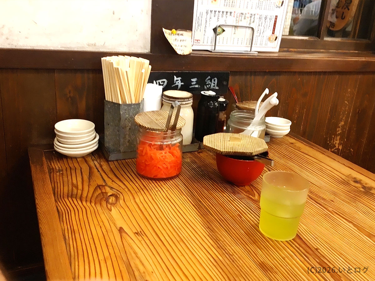 久留米とんこつラーメン松山分校の卓上調味料と薬味。紅しょうがなど本場久留米とんこつらしい定番