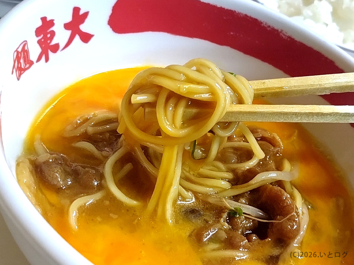生卵を絡めた徳島ラーメン東大の麺。甘辛い豚肉と濃厚豚骨醤油スープが絡む一杯。