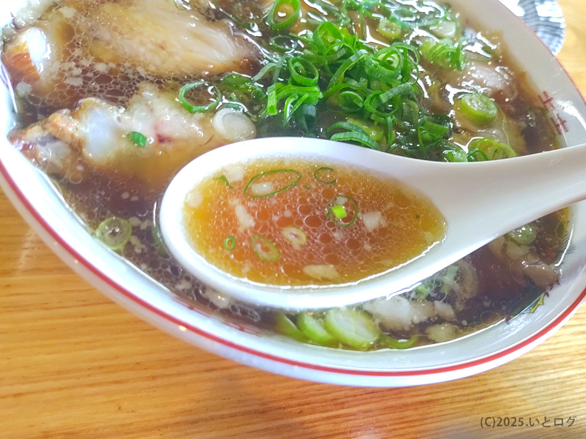 麺 㐂色のおすすめラーメン、澄んだ醤油スープをレンゲですくった様子。オーナー提供のこだわりが感じられる味わい。
