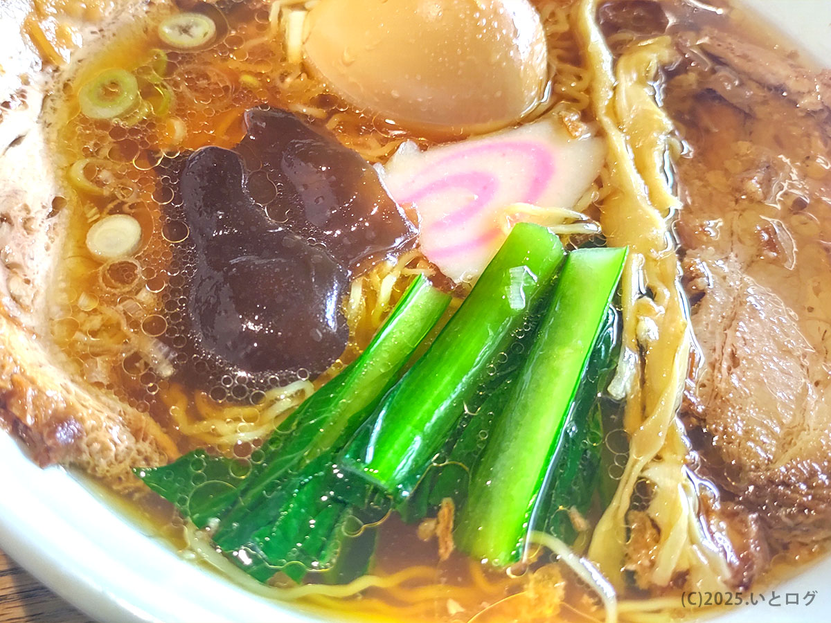 麺処 麗山のラーメン。青菜やメンマ、ナルト、煮卵など具材が彩り豊かに並ぶ。富士吉田市グルメやランチに人気の一杯。