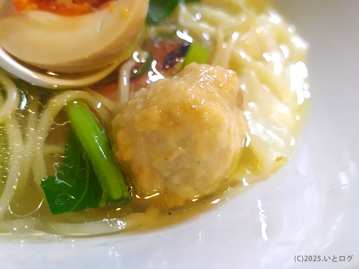 鶏そばAkari（甲府）の鶏白湯ラーメンに添えられた鶏団子と青菜のアップ。鶏の旨味が詰まった具材と澄んだスープが特徴の山梨ラーメン。