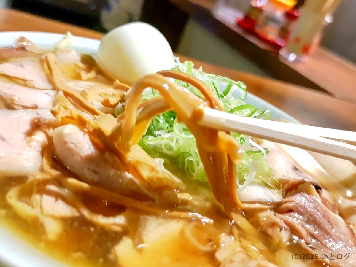「中華蕎麦よるのふじのラーメン。箸で持ち上げたメンマの下に、チャーシューとネギが美しく重なる。富士吉田の夜に香り立つ一杯。」