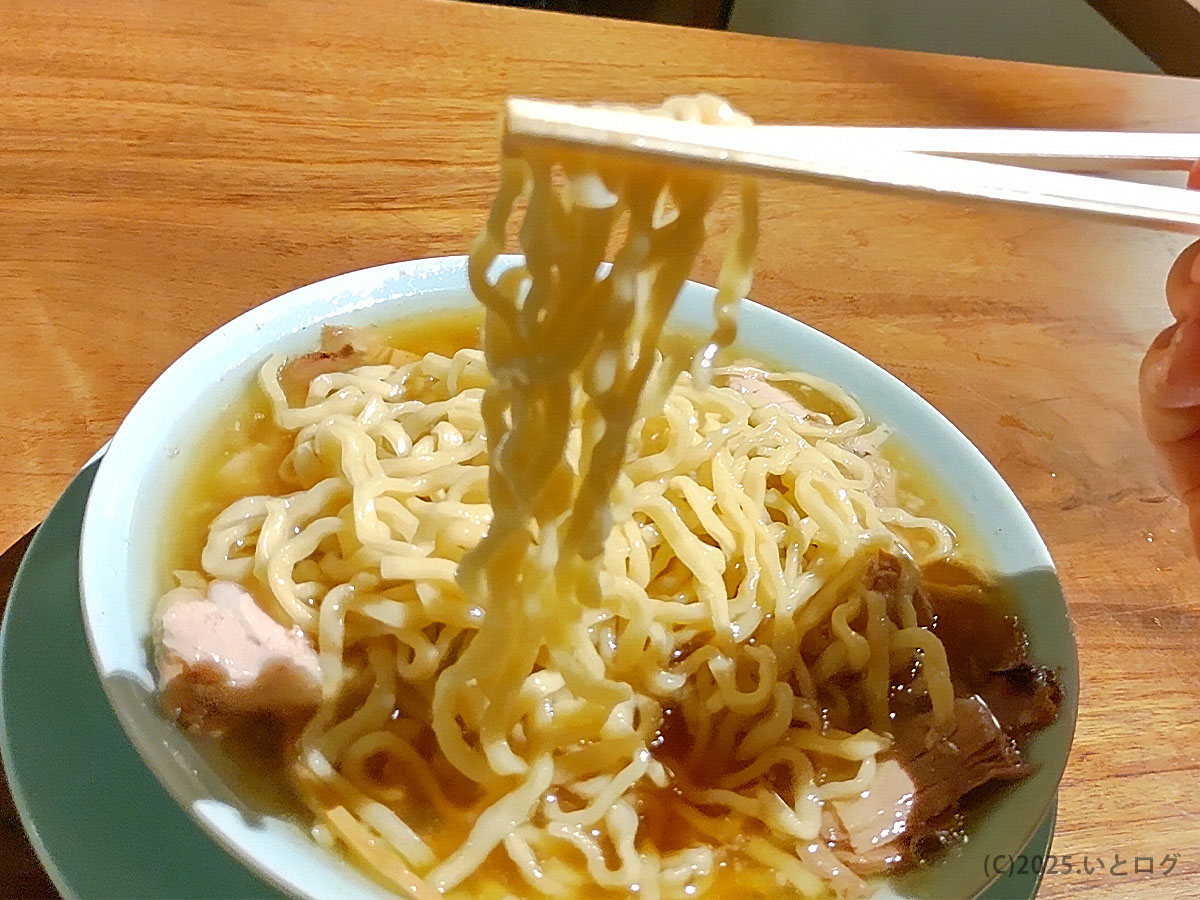 「中華蕎麦よるのふじの醤油ラーメン。もちもちの縮れ麺を箸で持ち上げた瞬間。湯気の向こうに富士吉田の夜がにじむような一枚。」