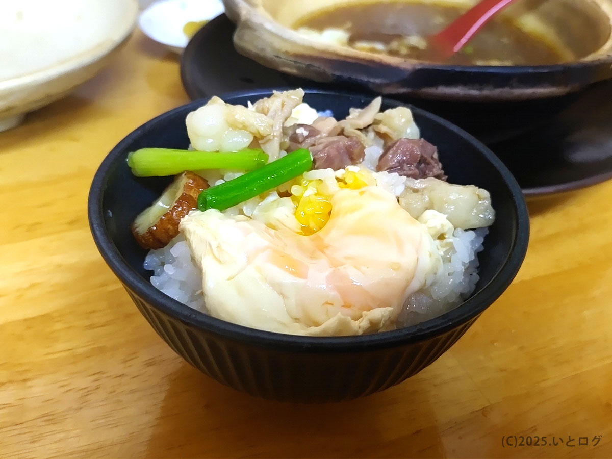 鍋焼きラーメンの具材をご飯に乗せた“追い飯”。半熟卵・鶏もつ・青ねぎが彩る、まゆみの店 鍋焼きラーメンのシメ。