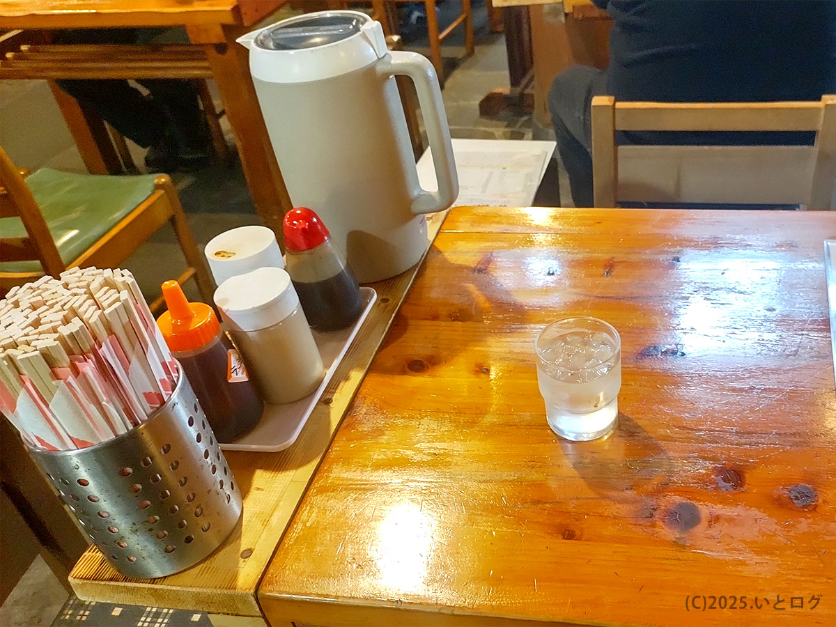 醤油・ソース・ラー油と大量の割り箸、大容量ポットが並ぶセルフサービス仕様の卓上。自由軒 高知 大津店らしい気取らなさ。