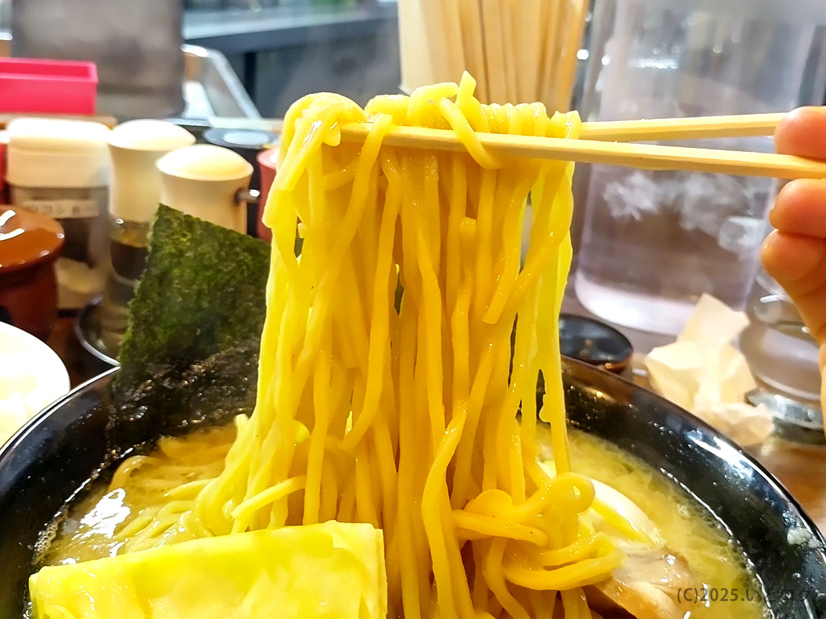 立ちのぼる湯気とともに黄金色の麺をリフト。寸八 メニューの中でも人気の一杯を堪能する瞬間。