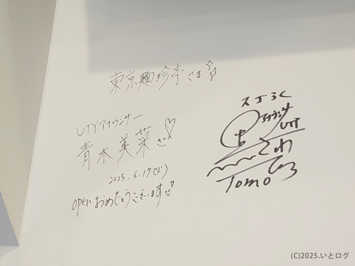 UTYアナウンサー青木美菜らの直筆サインが壁に残る店内。東京麺珍亭本舗を訪れた著名人の祝福メッセージが並ぶ。