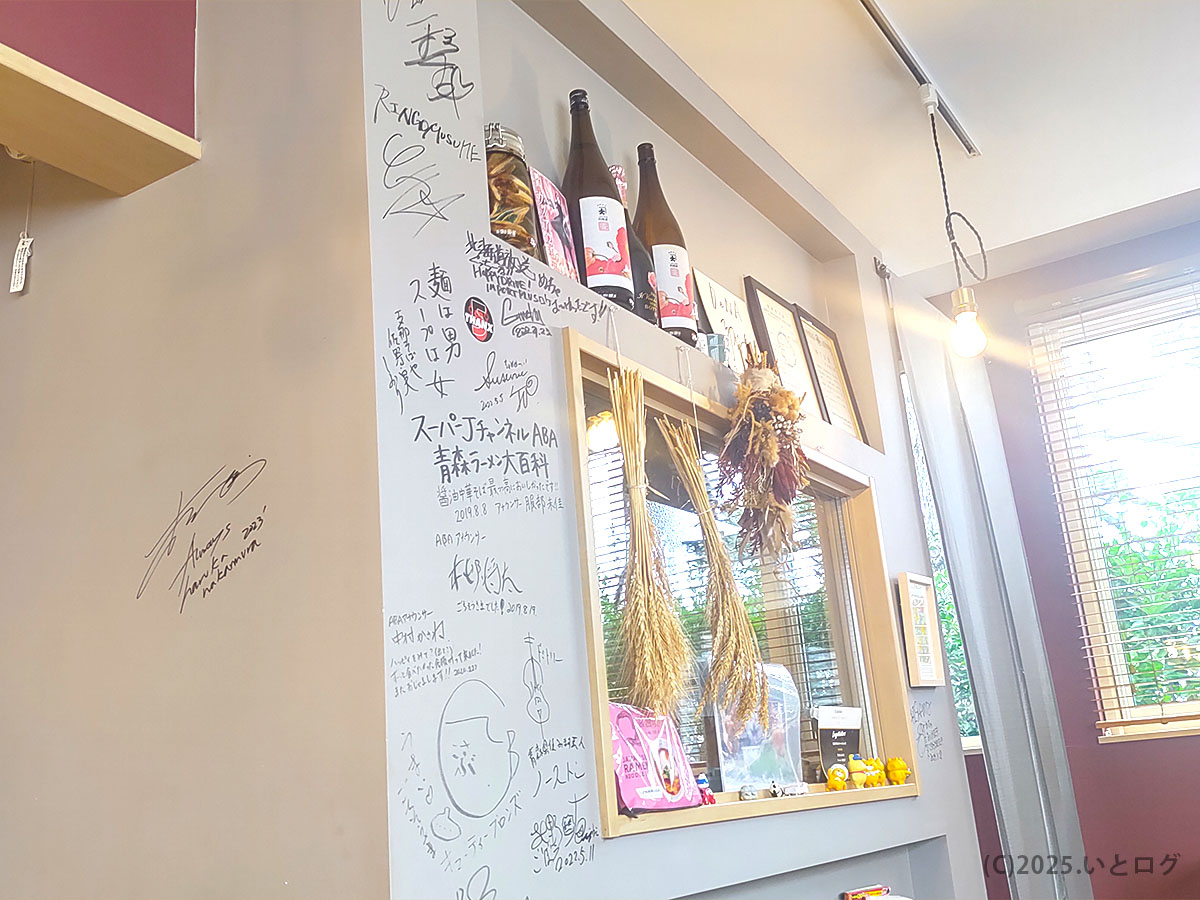 青森中華そばオールウェイズの店内壁に並ぶサインや装飾。落ち着いた雰囲気のラーメン店内