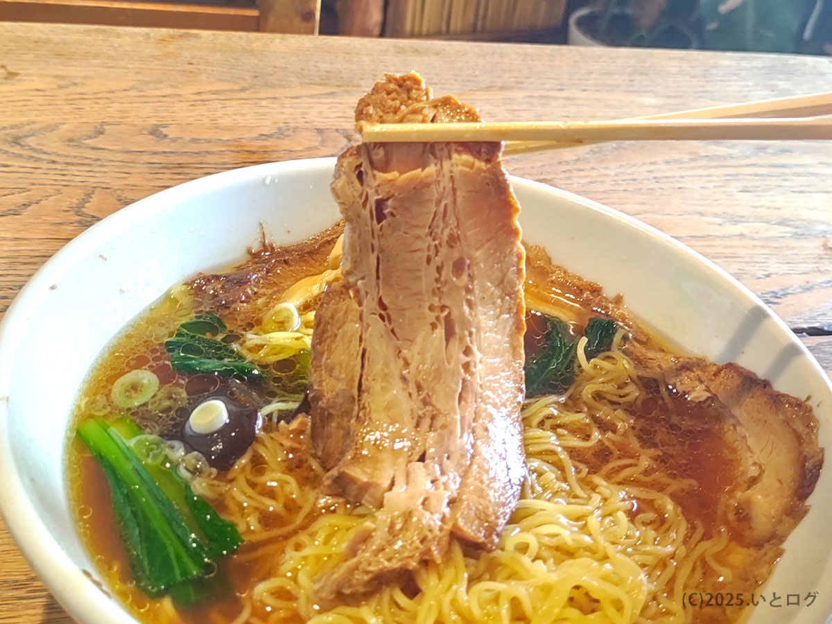 麺処 麗山の大きなチャーシューを箸で持ち上げたところ。山梨県富士吉田市で味わえるおすすめラーメンの魅力。