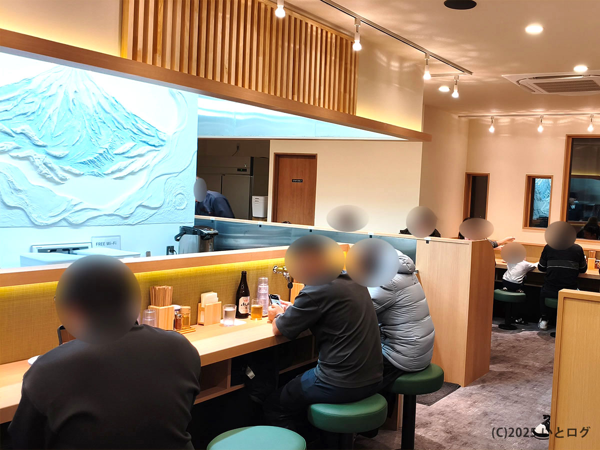 「らぁ麺 八葉」の店内カウンター席。壁面には富士山のレリーフが施され、観光地・河口湖らしい演出。デートや観光の昼食にも最適。