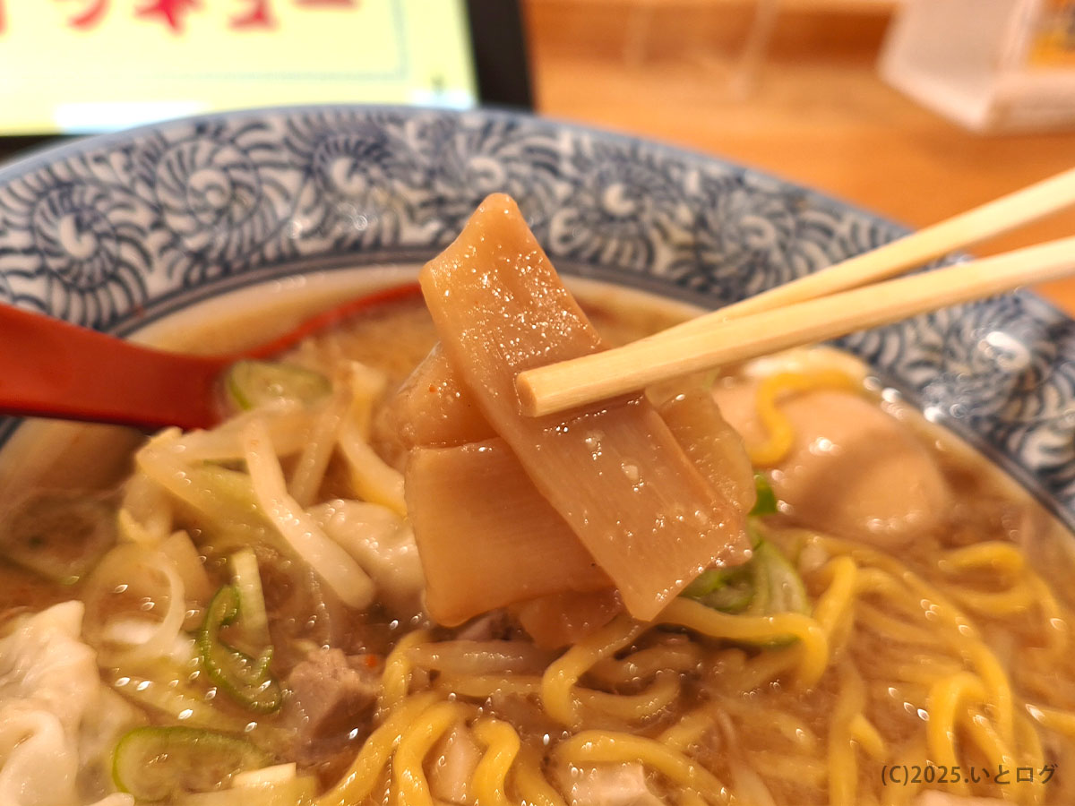 中華そばイッキューのメンマを箸でつまんだ様子。ほんのり甘みのある味付けで、麺やスープの旨みを引き立てる。