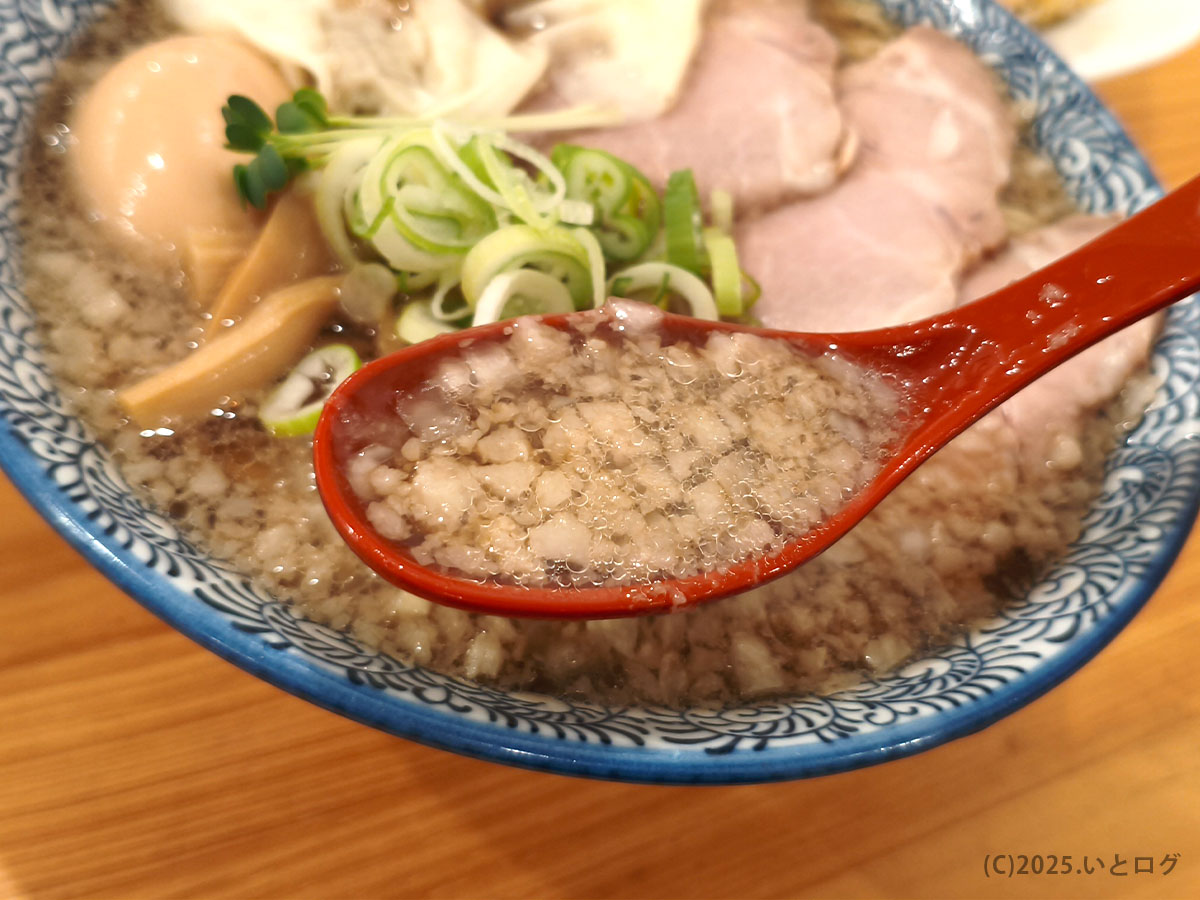 中華そばイッキューの背脂スープをレンゲですくったところ。刻み背脂がしっかり浮き、こってり感の強い山梨市ラーメンらしいスタイル。