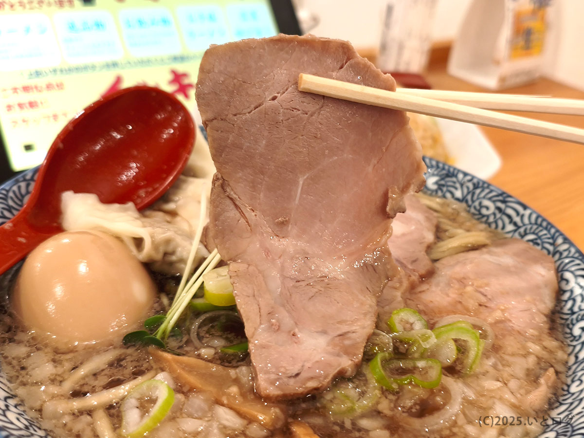 中華そばイッキューの大判チャーシューを持ち上げた様子。程よく脂が入り、肉の旨みがしっかり感じられる柔らかい仕上がり。