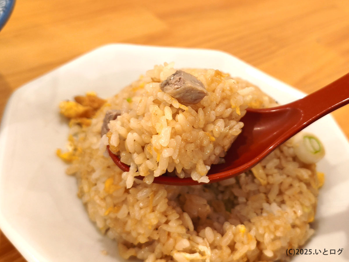 中華そばイッキューのチャーハンをレンゲで持ち上げたアップ。パラッと香ばしく炒められ、角切りチャーシューも入った食べ応えのある一品。