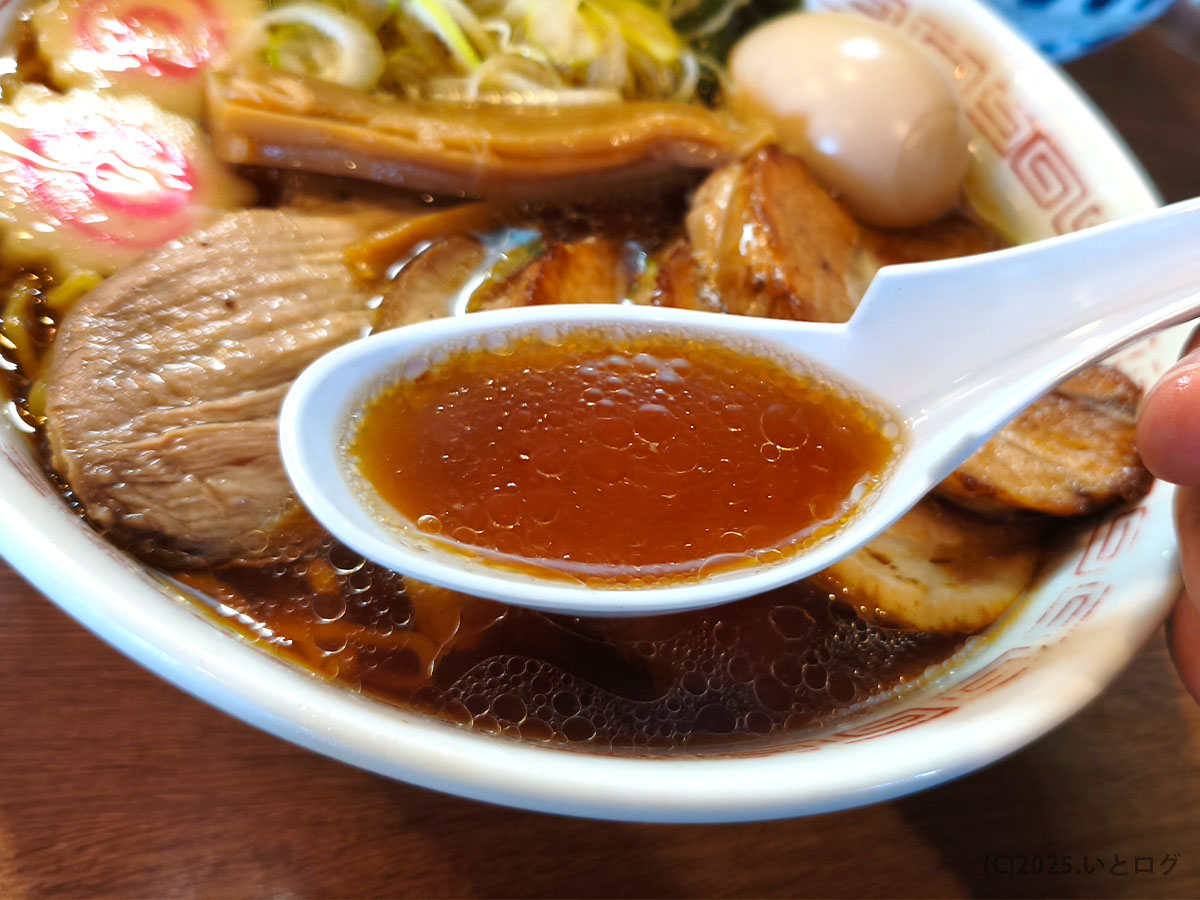 三角屋 暖の中華そば、醤油の色味が際立つスープをレンゲですくった一枚