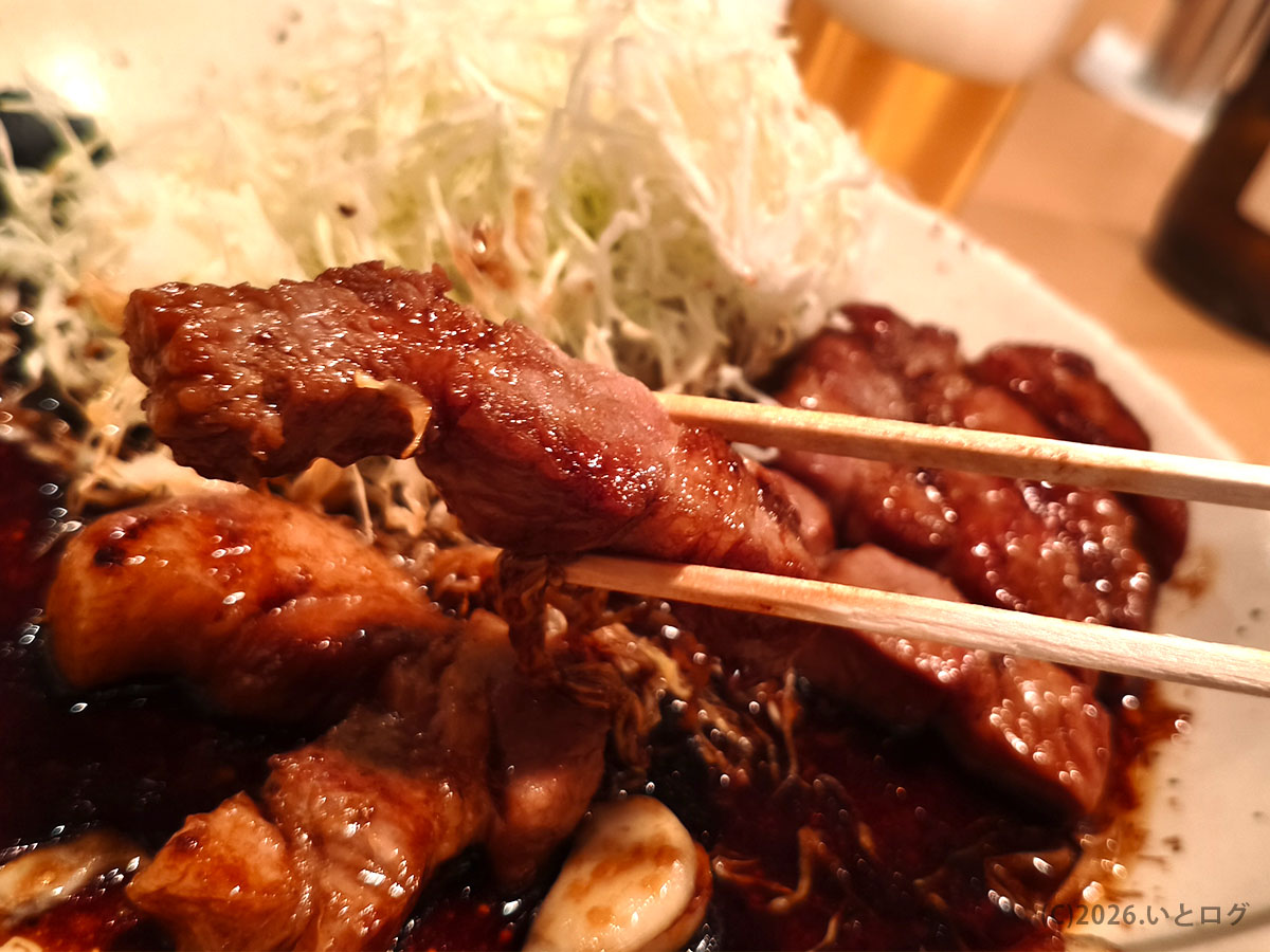 トンテキ屋ちゃん四日市店のトンテキを箸で持ち上げた様子。やわらかそうな豚肉と特製ソース