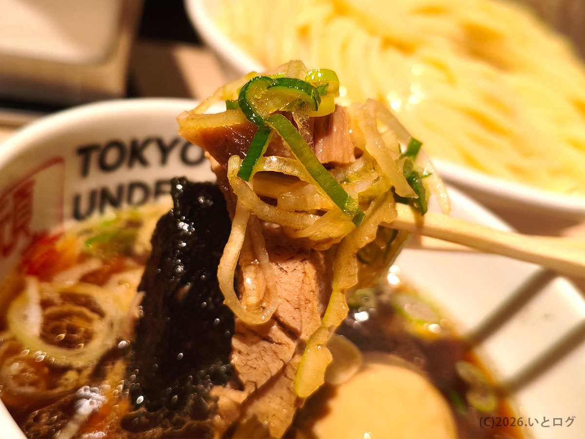 頑者 池袋 つけ麺の具材アップ｜チャーシューとネギを持ち上げた一口