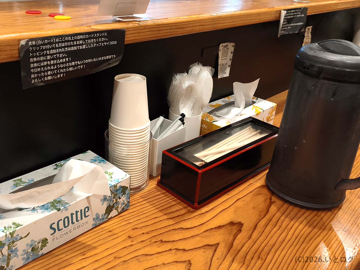 夢を語れ長崎の卓上調味料や紙エプロン置き場。初心者向けに注文方法や案内も掲示されている
