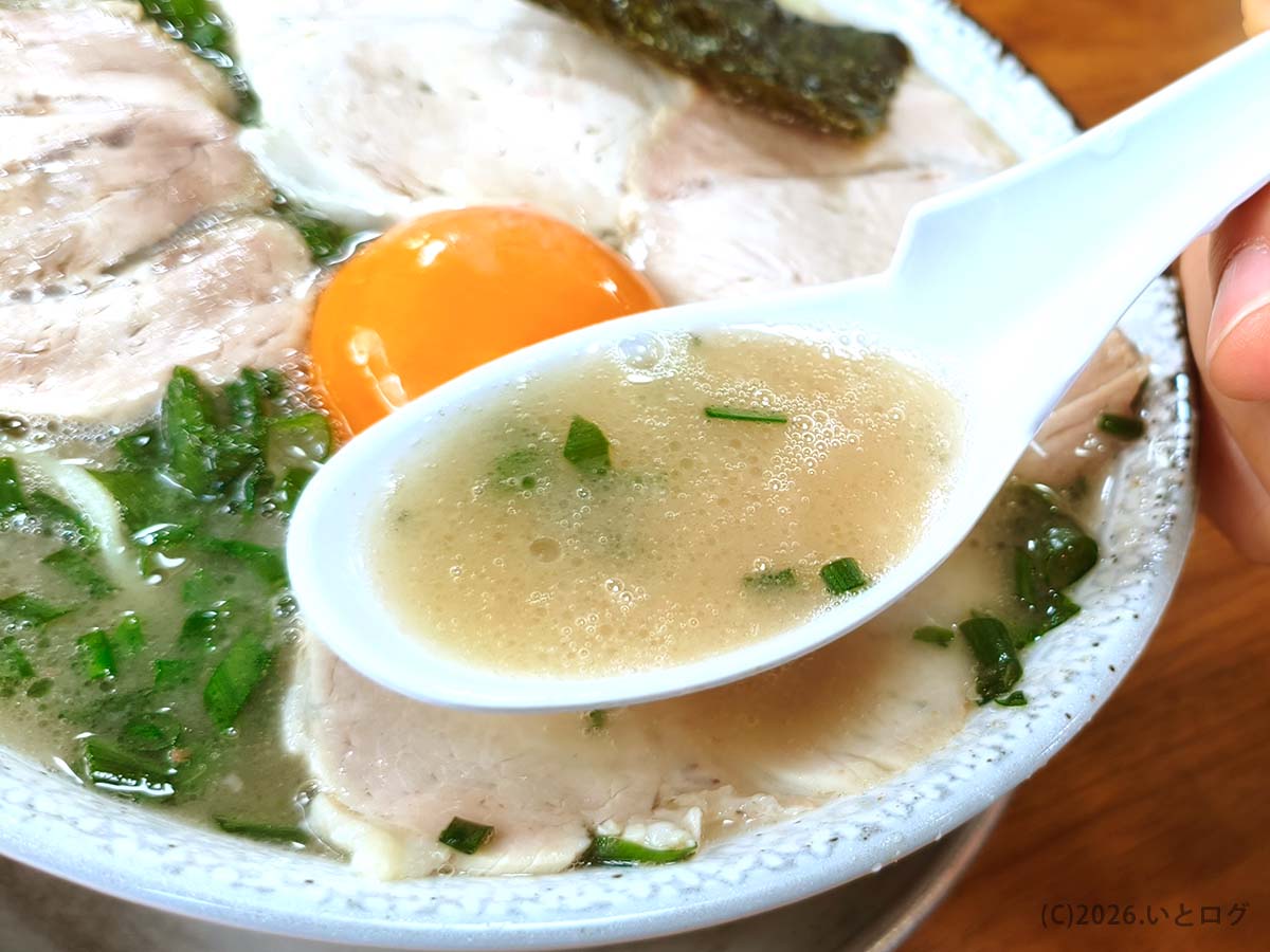 幸陽閣 佐賀のラーメンスープをレンゲで持ち上げた様子 濃厚ながらまろやかな豚骨スープが特徴