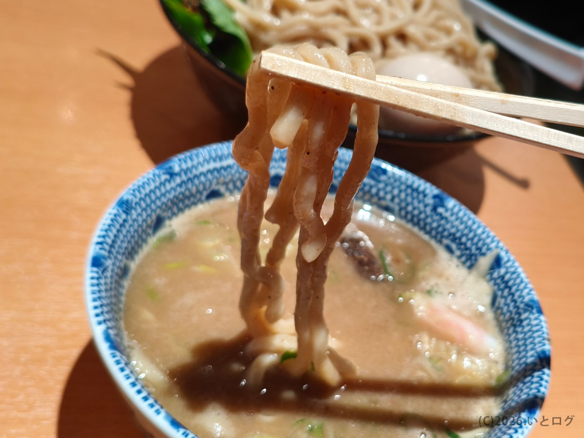 六厘舎 東京駅の太麺をつけ汁にくぐらせた様子。もちもちした麺が濃厚スープによく絡む
