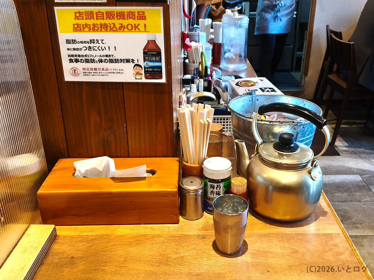 大島ラーメンの卓上調味料とポット。シンプルで清潔感のあるカウンター周り