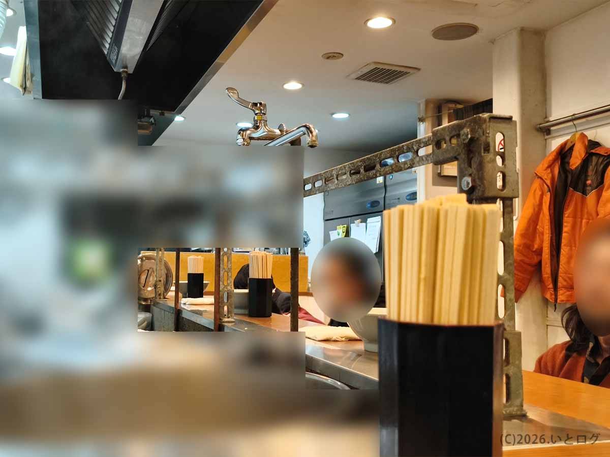 店内カウンター越しに見える横浜家系ラーメン 武蔵家 秋津店の厨房と客席の様子。秋津駅近で深夜ラーメン需要も高い人気店