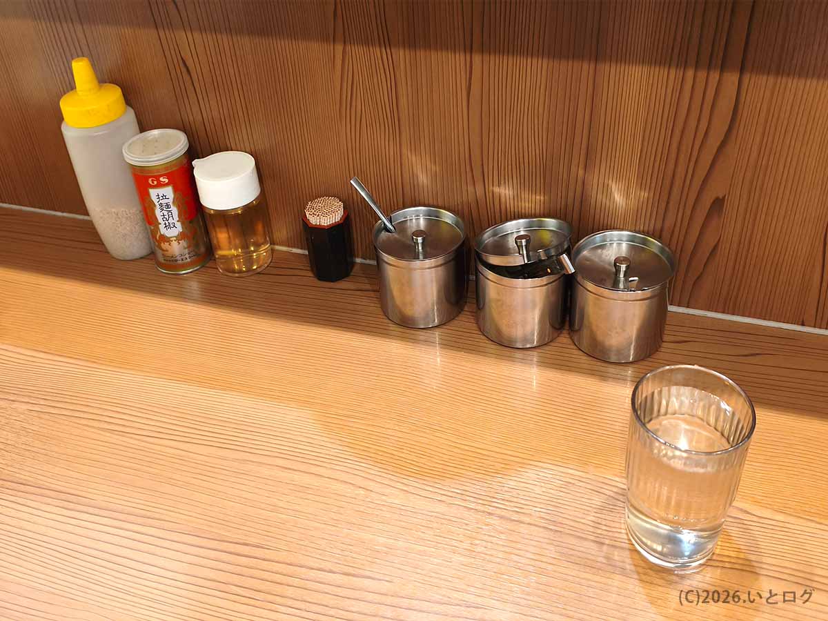 武蔵家 秋津店の卓上調味料とカウンター席。にんにくや豆板醤が並ぶ秋津の家系ラーメン店