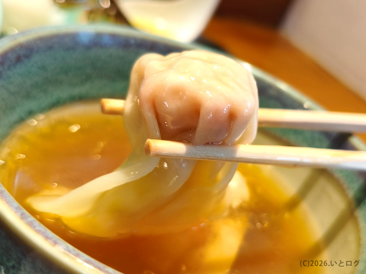 入鹿TOKYO本店のつけ麺に入るワンタン。つけ汁の中から持ち上げた瞬間のアップ。