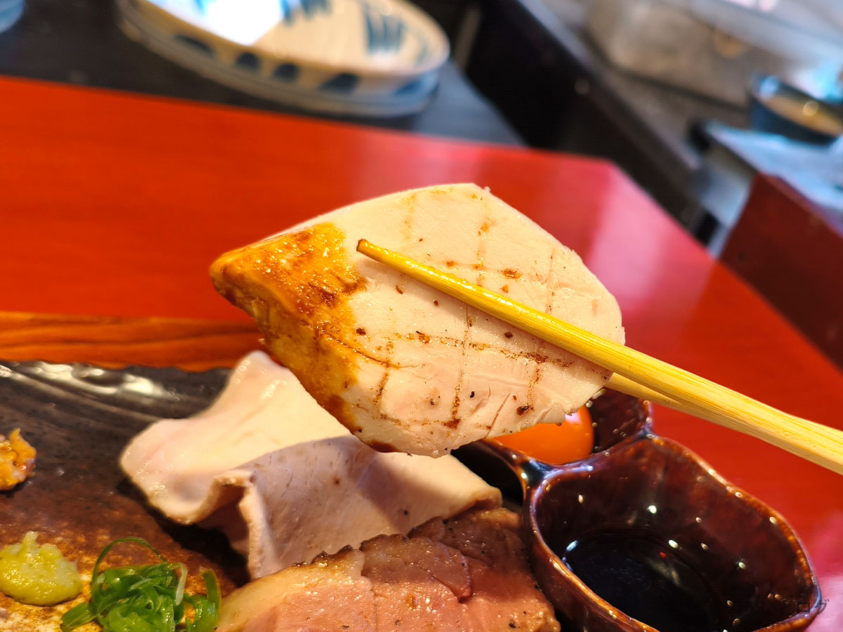 中華そば 鴨福で提供される低温調理の鶏むね肉を箸で持ち上げたアップ写真
