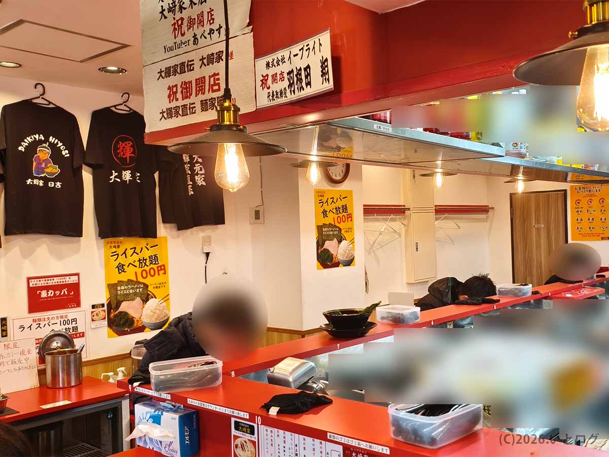 大輝家系譜の「大﨑家 末広町店」の店内。赤いカウンターが印象的で、ライスバー食べ放題100円の掲示も目立つ秋葉原近くの家系ラーメン店