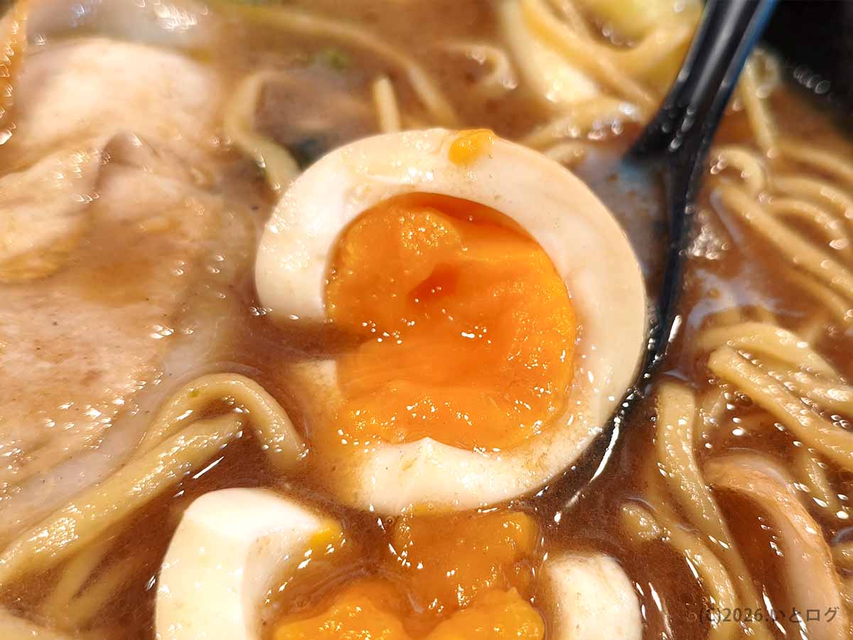 大﨑家 末広町店の味玉を割った瞬間。濃厚な豚骨醤油スープの中から、とろっとした黄身が流れ出してくる