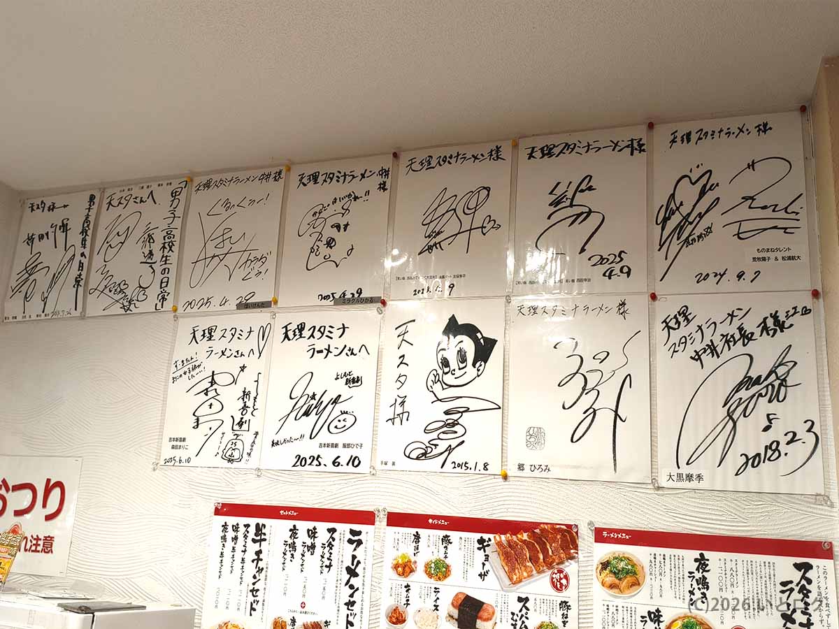 天理スタミナラーメン本店の店内に飾られた著名人のサイン色紙が並ぶ壁面